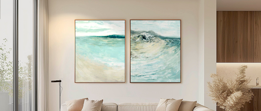 Wall art for living room — large abstract canvas prints in pale blues and sand displayed above a sofa, beautiful statement art for living rooms by Kate Shephard Art.