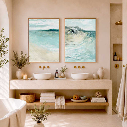 'Coastal Calm' - Set of 2 beach art paintings displayed above a sofa, soft coastal palette in blue and cream.